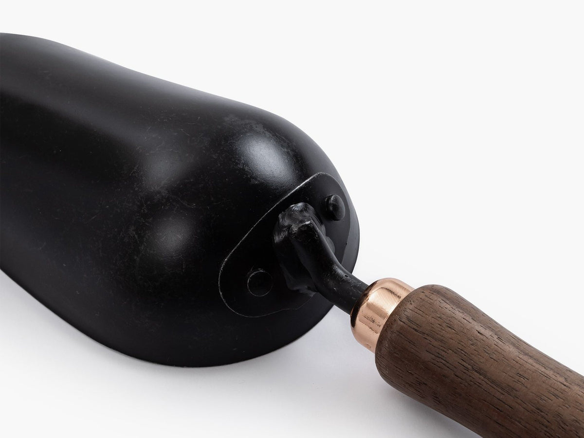 A black Garden Scoop with a wooden handle by Barebones.