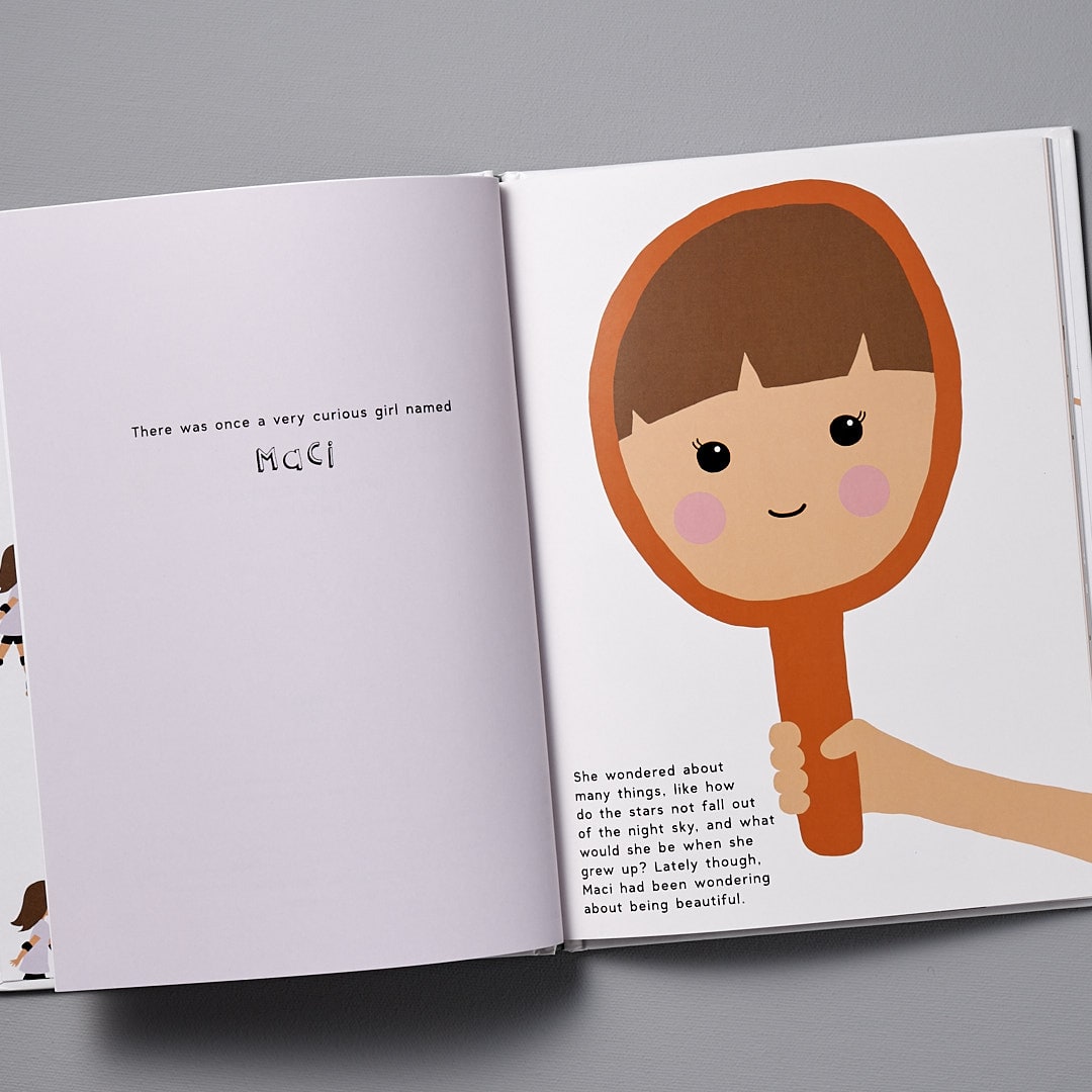 An open children&#39;s book with an illustration of a cartoon girl radiating Beautiful beauty by Becky Kemps next to text of a story.