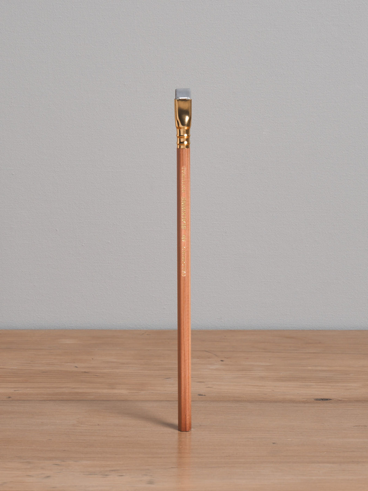 A Blackwing Natural Pencil, made by Palomino Blackwing, sitting on top of a wooden table.
