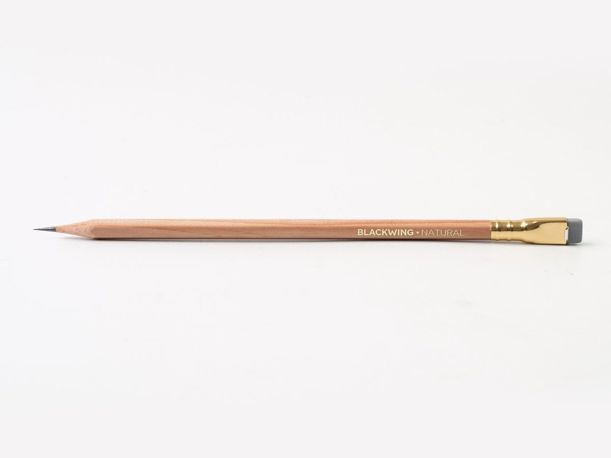 A Blackwing Natural Pencil with a gold tip on a white surface. (Brand Name: Palomino Blackwing)