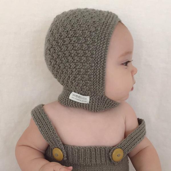 A baby wearing a Weebits grey hand knitted rompers - Mushroom hat.