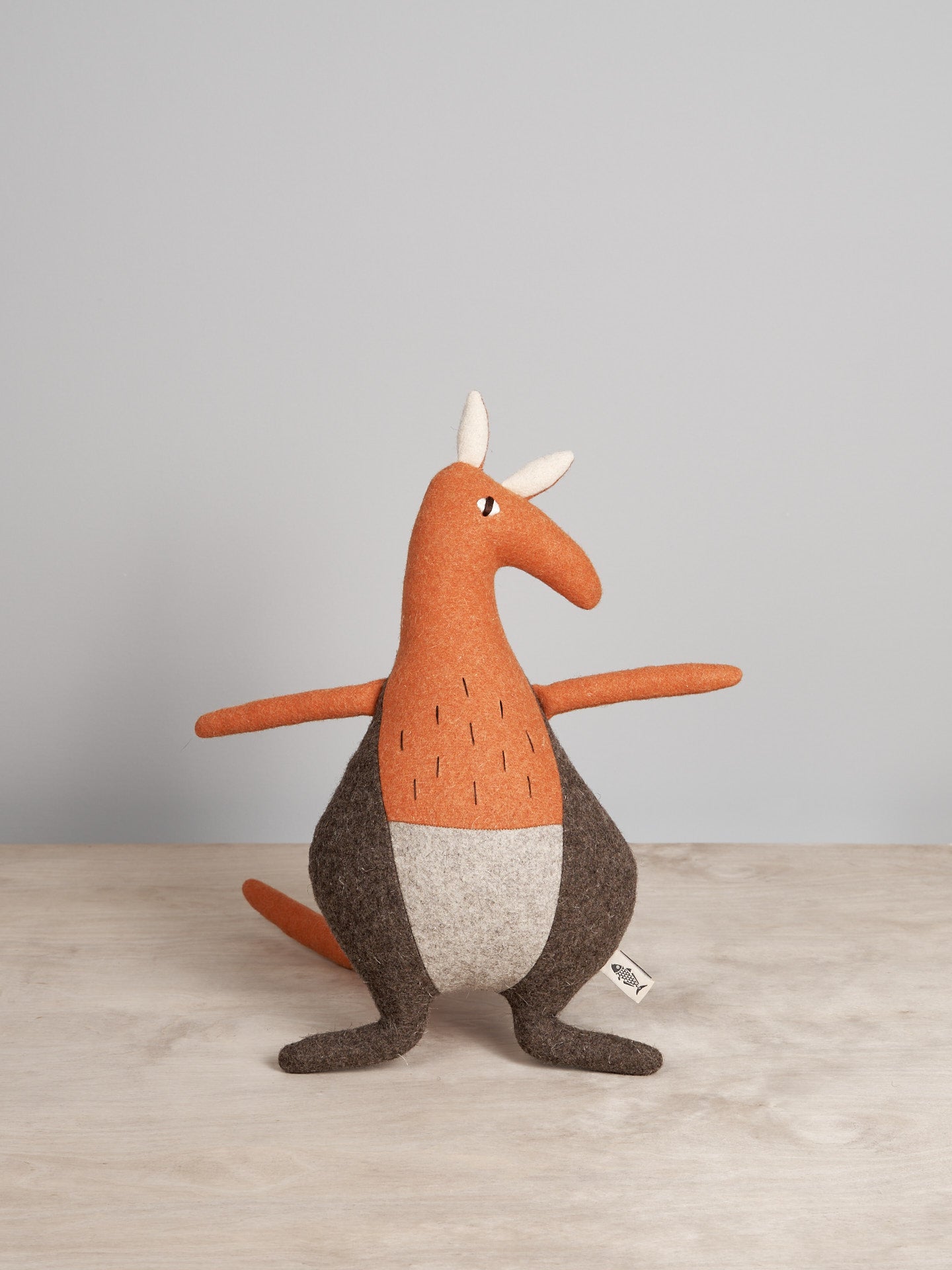 A JOE, the Kangaroo toy sitting on a wooden table by Carapau.