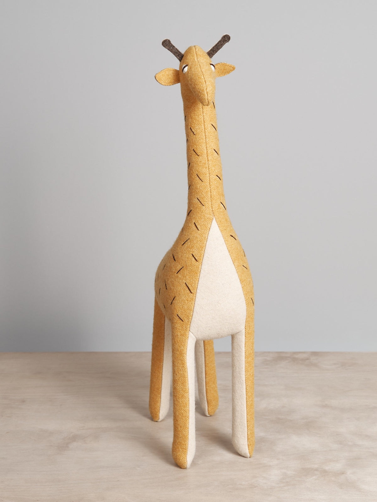 A Carapau ZIFFA, the Nubian giraffe, standing on a wooden table.
