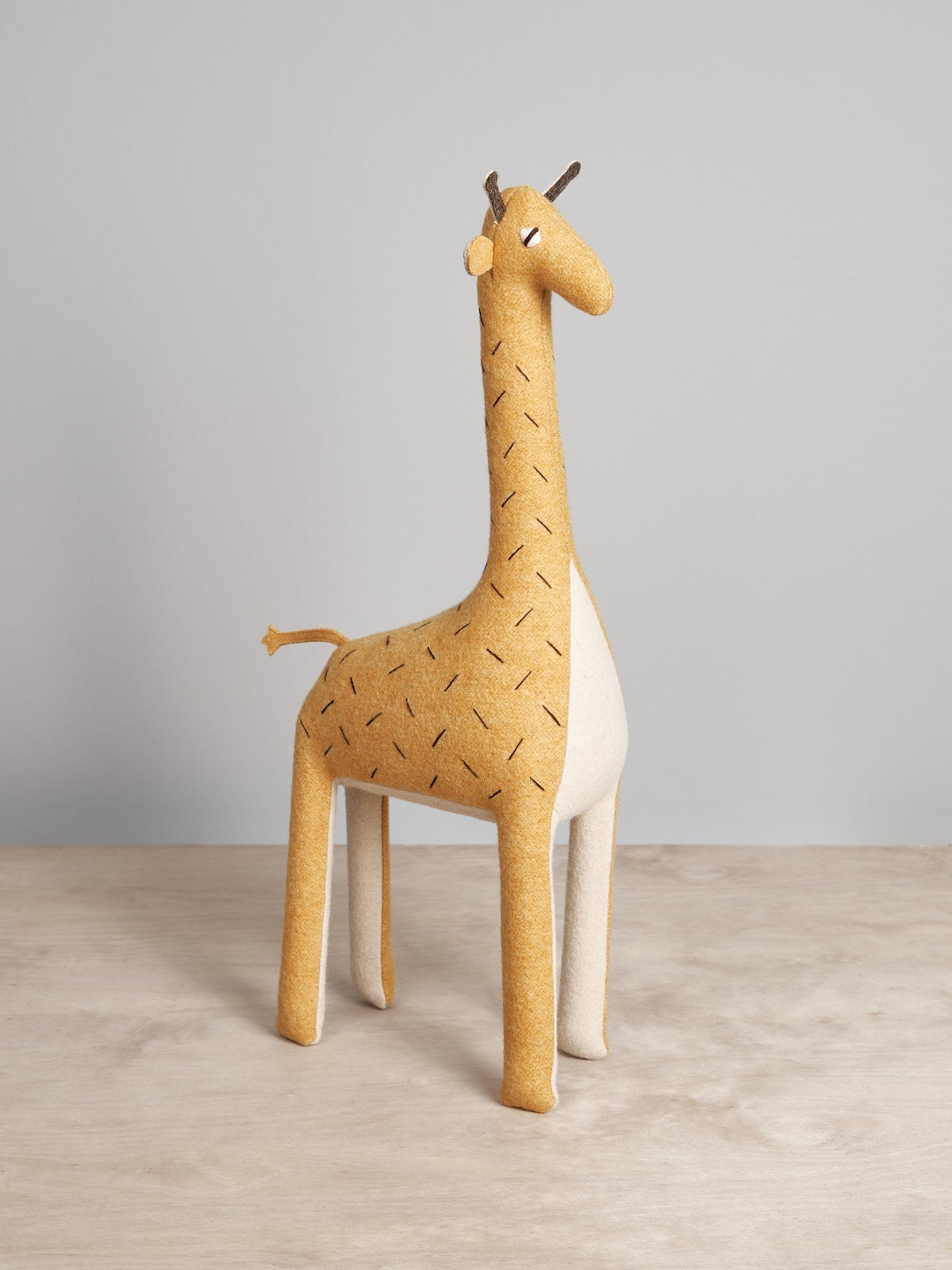 A ZIFFA, the Nubian giraffe, sitting on a wooden table.