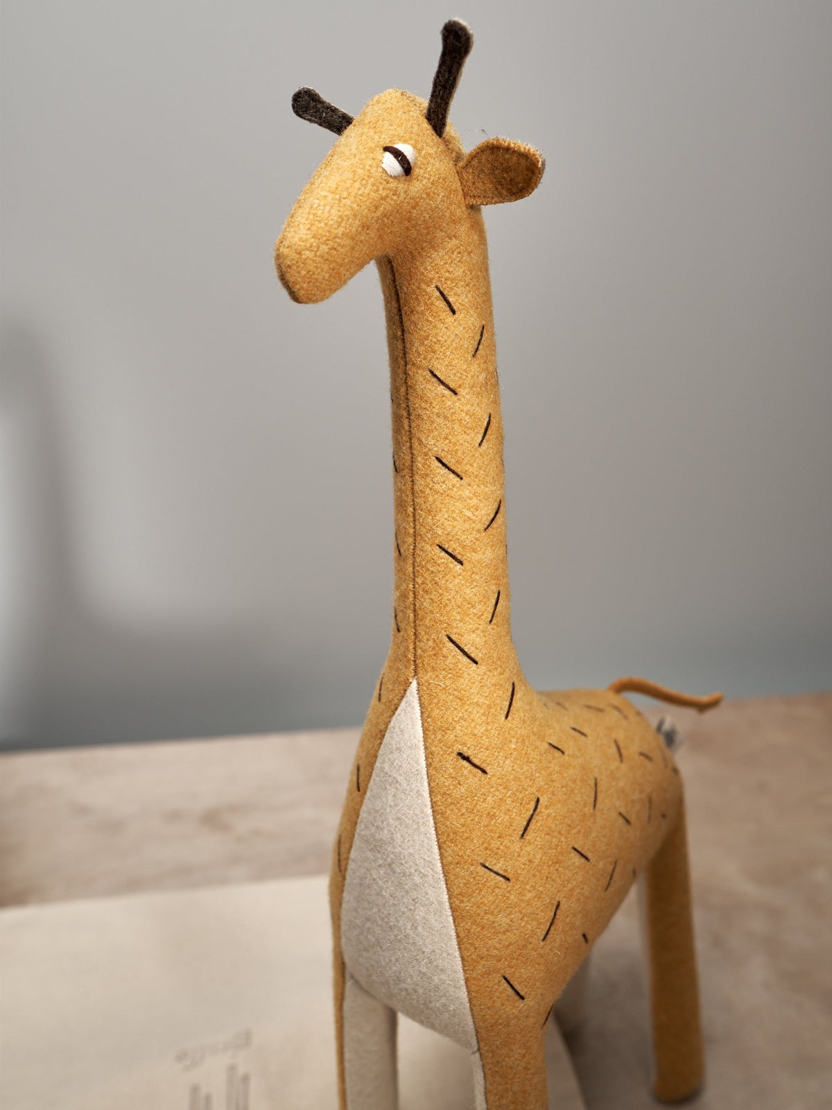 A ZIFFA, the Nubian giraffe toy on a table. (Brand Name: Carapau)