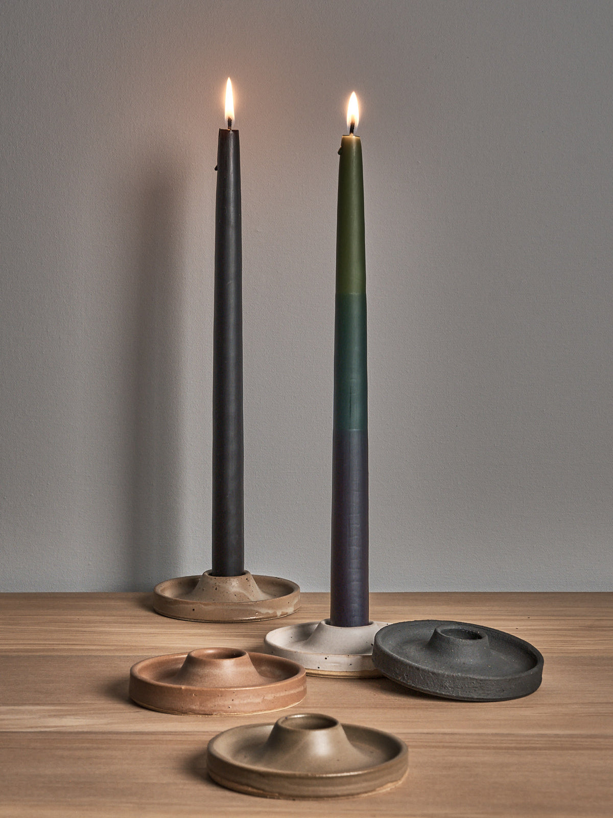 Three Deborah Sweeney candle holders in the Moss design on a wooden table next to each other.