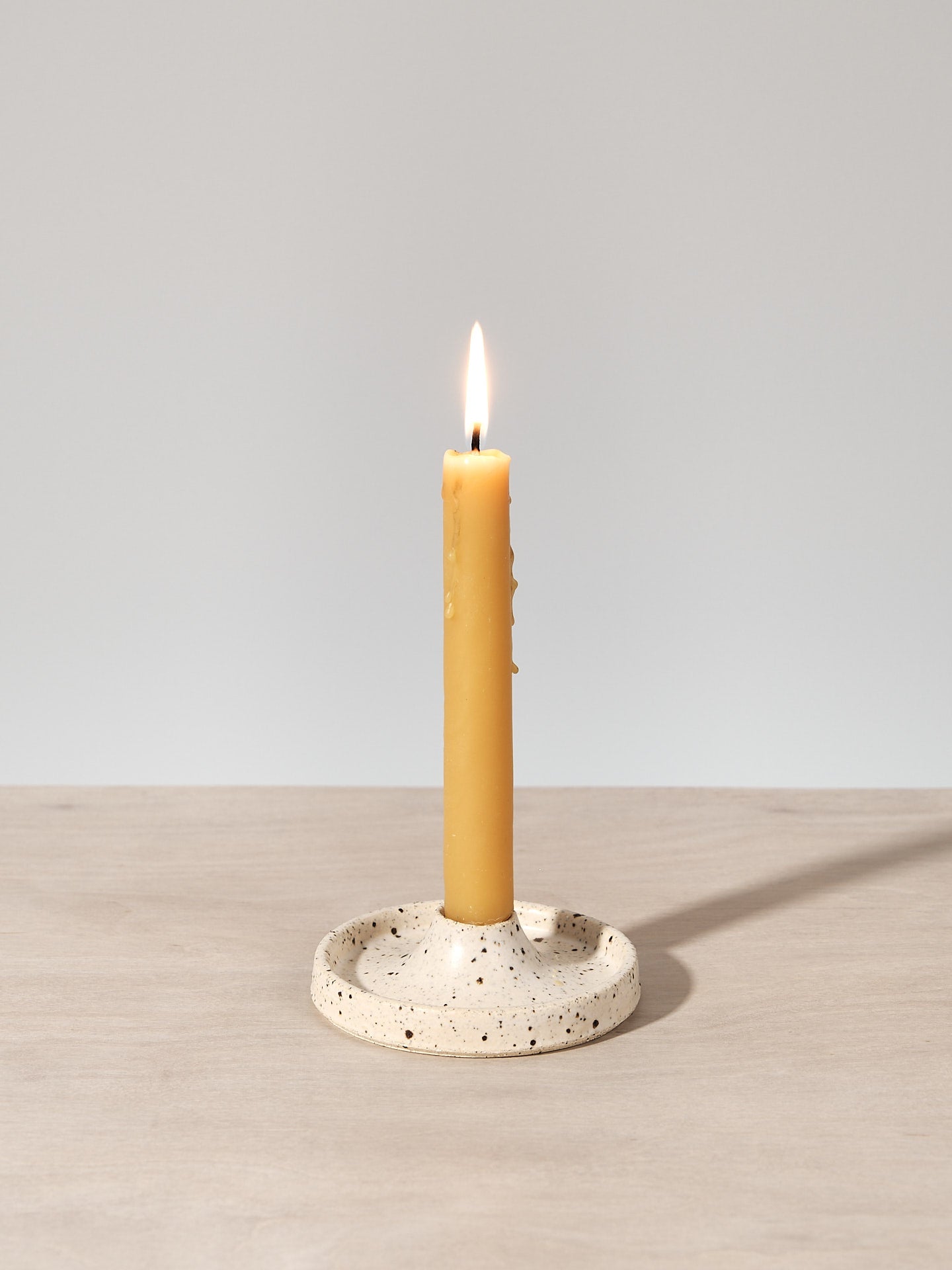 A deborah sweeney Candle Holder – Toi Toi is sitting on top of a wooden table.