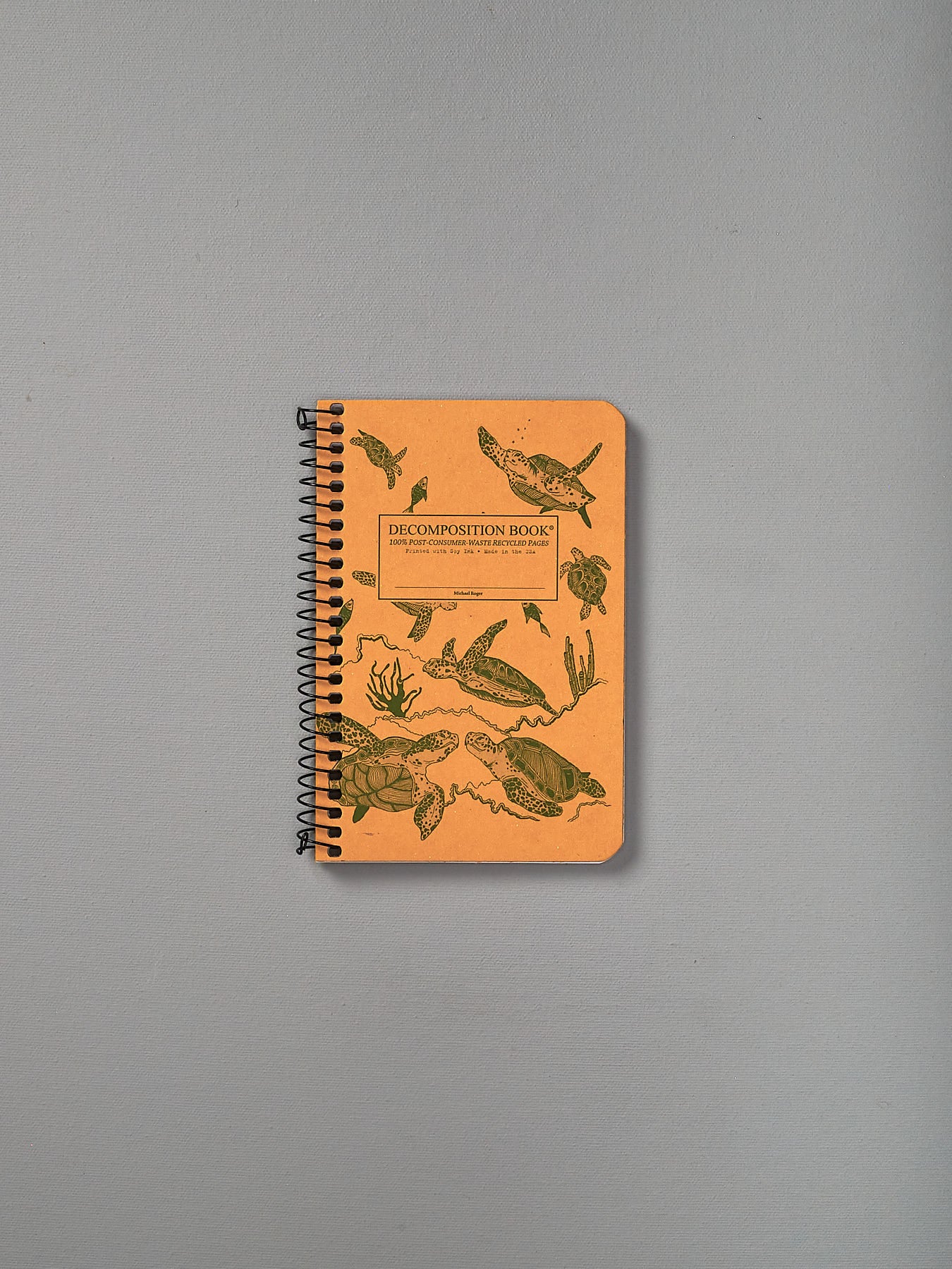 A Decomposition Recycled Notebook - Pocket Sized/Ruled (Sea Turtles) with a drawing of a fish on it.