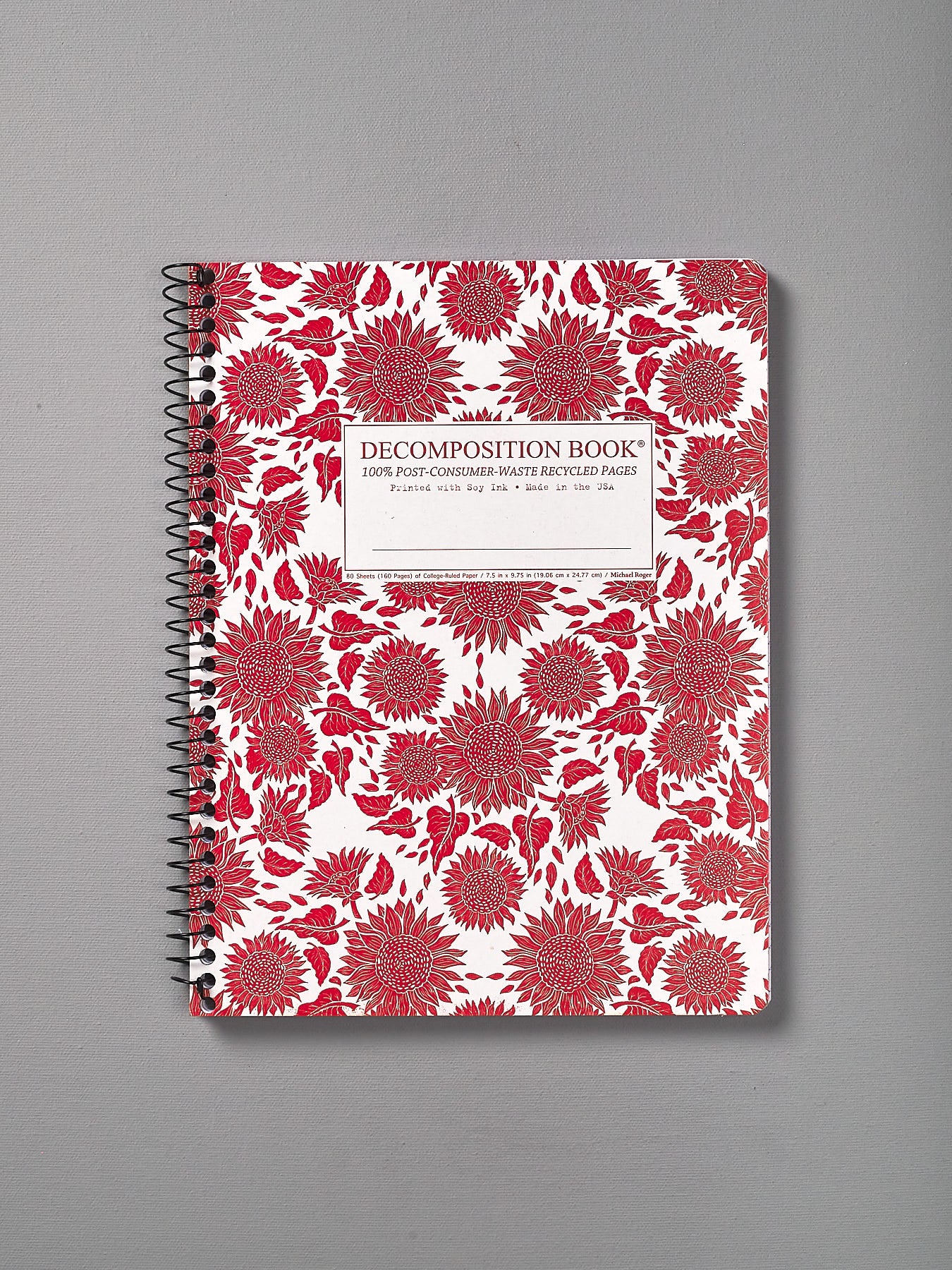 A Decomposition Recycled Notebook – Large/Ruled (Sunflowers) with red and white flowers on it.