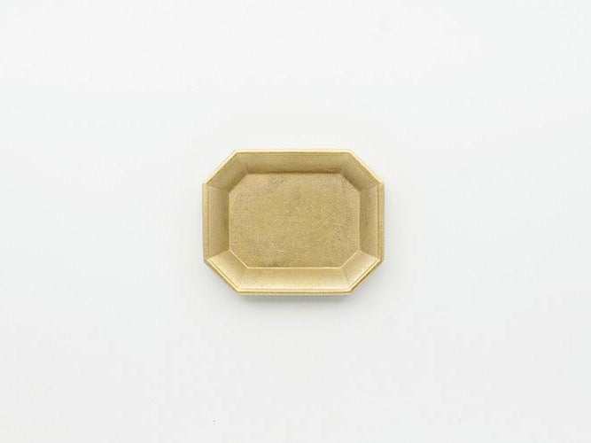 An Octagon Shaped Stationery Tray – Solid Brass on a White Background by Futagami.