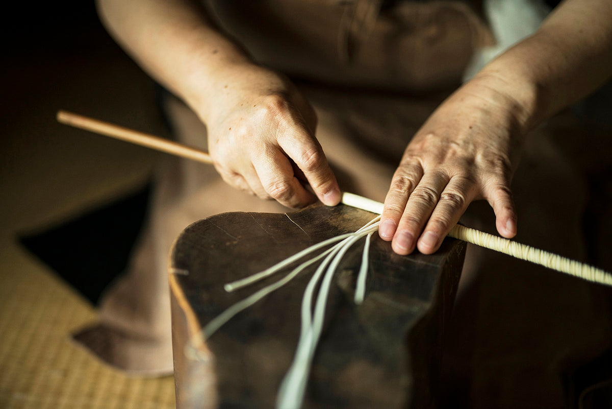 Japanese woman making a kimono with a Takazawa bamboo stick.
