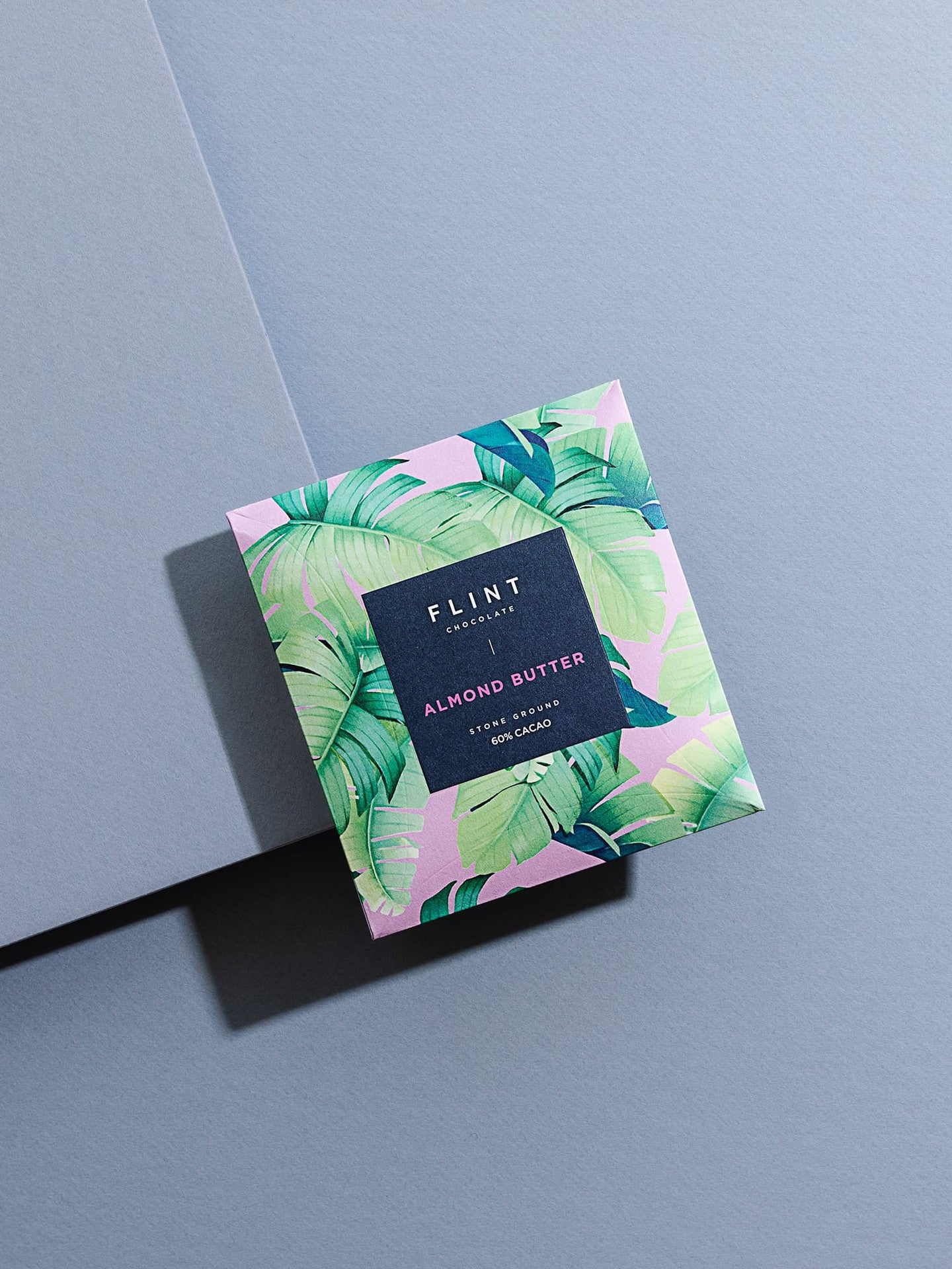 A Flint Chocolate Almond Butter Chocolate Bar with a pink and green leaf on it.