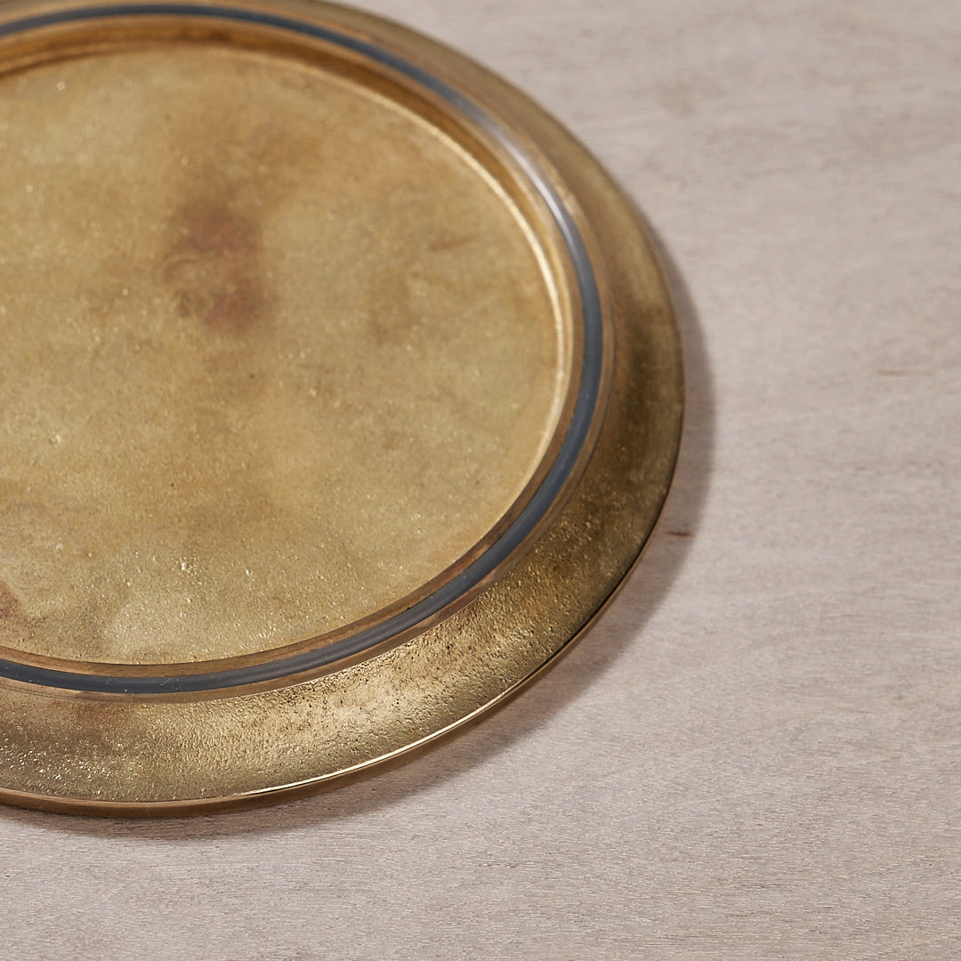 A Kobo Coaster – Solid Brass by Futagami plate on top of a wooden surface.