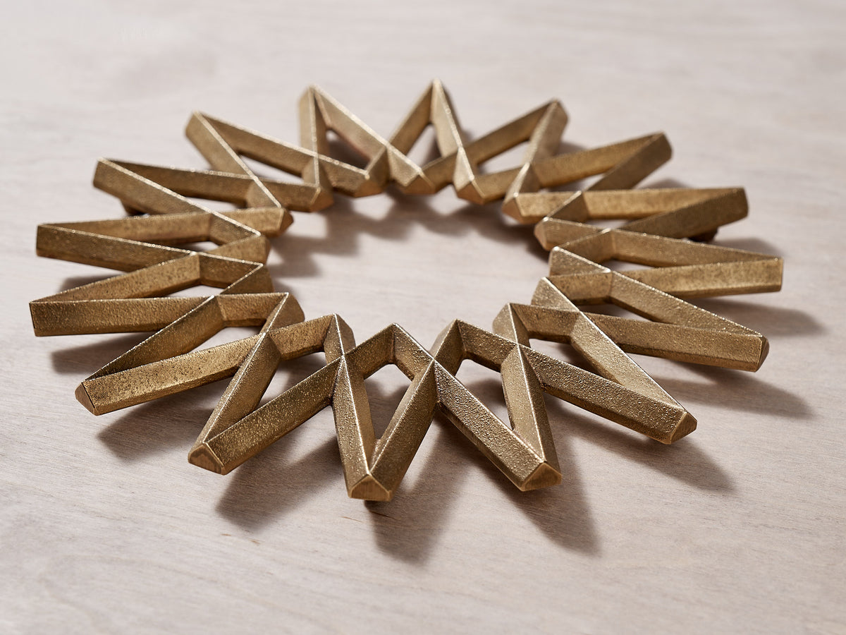 A Galaxy Trivet – Solid Brass arranged in the shape of a star by Futagami.