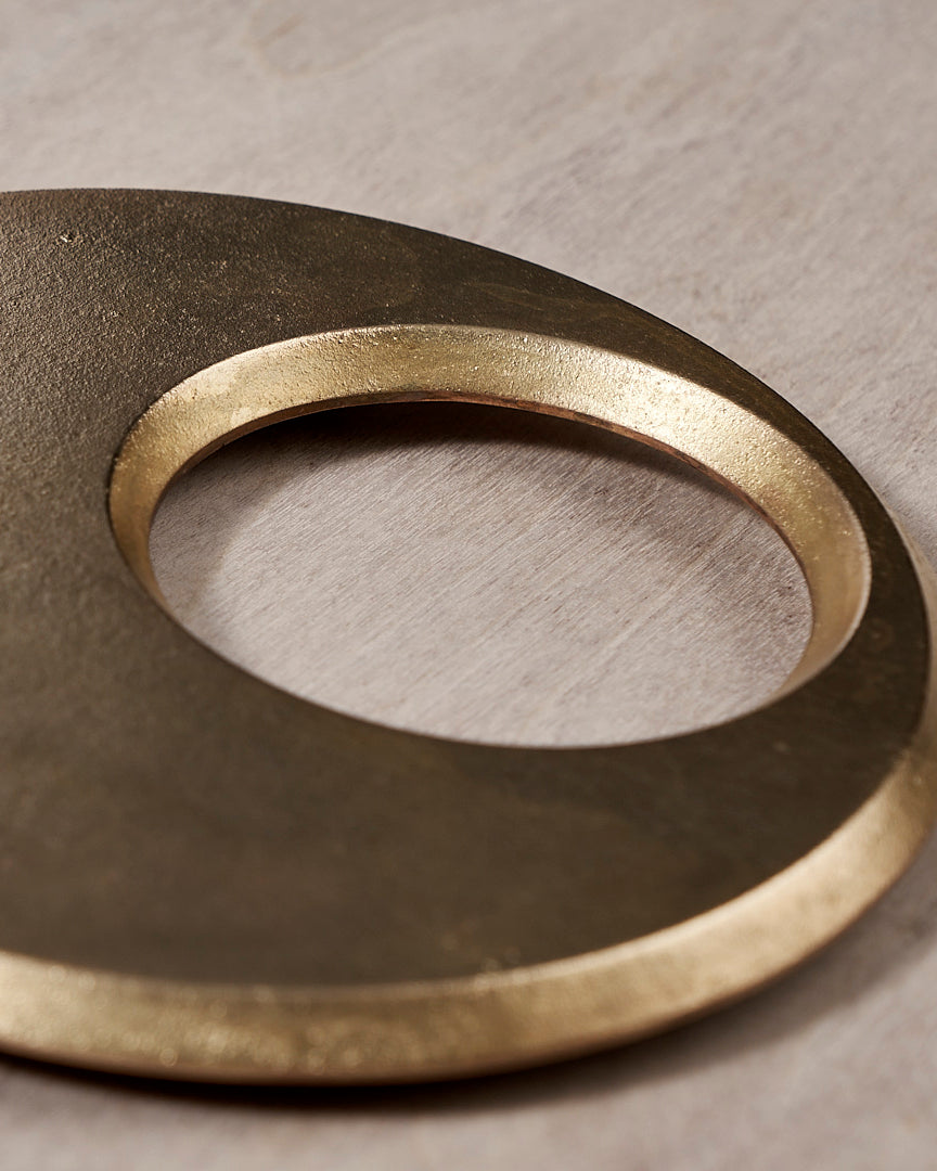 A Moon Trivet – Solid Brass by Futagami on a wooden surface.