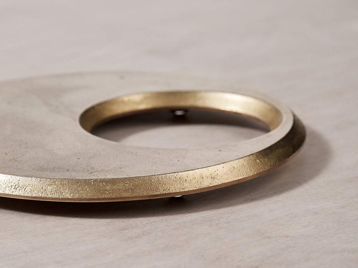 A Moon Trivet - Solid Brass by Futagami on a wooden surface.