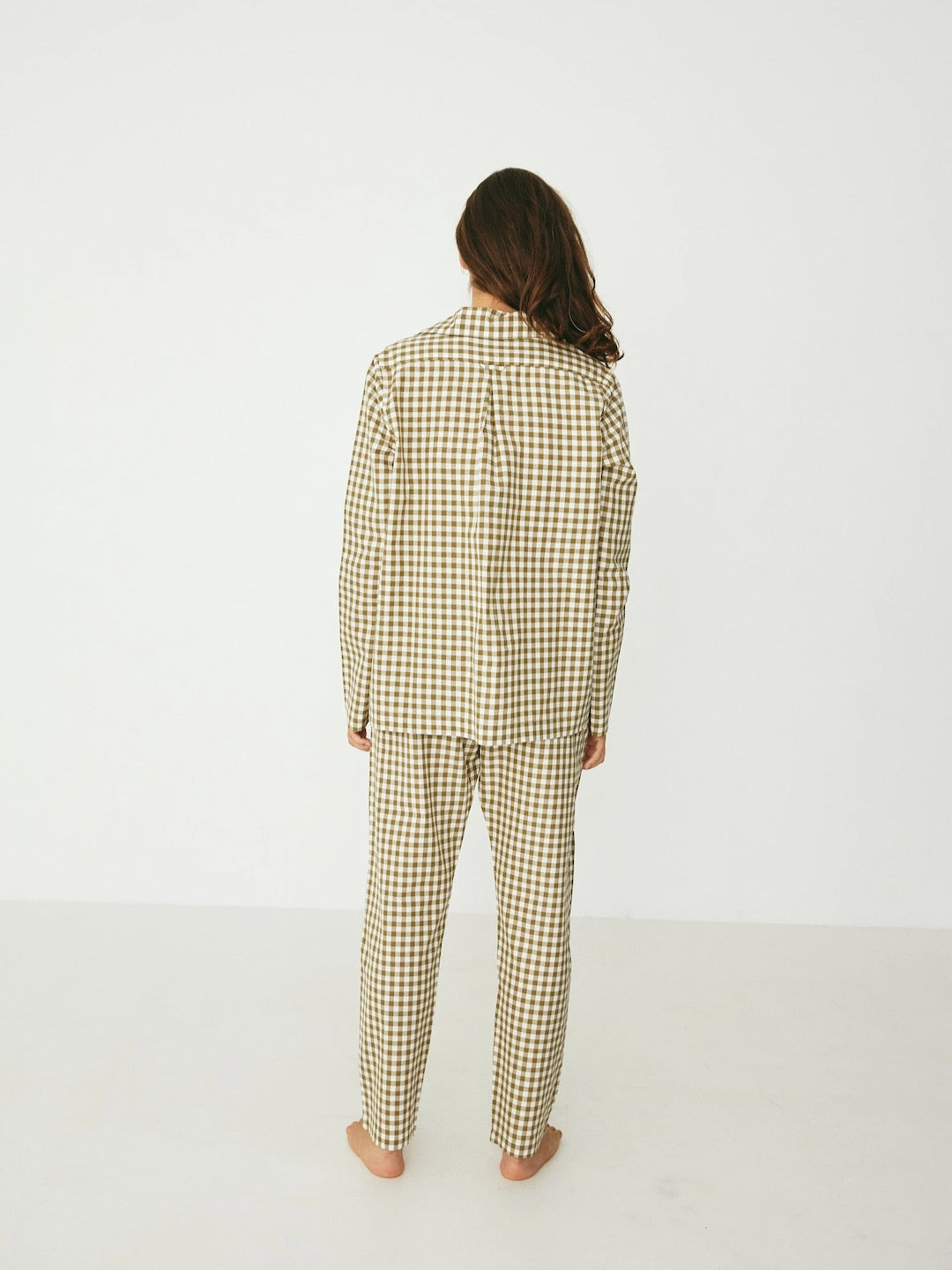 The back view of a woman wearing a Classic Set – Olive Gingham pajama set from general sleep.