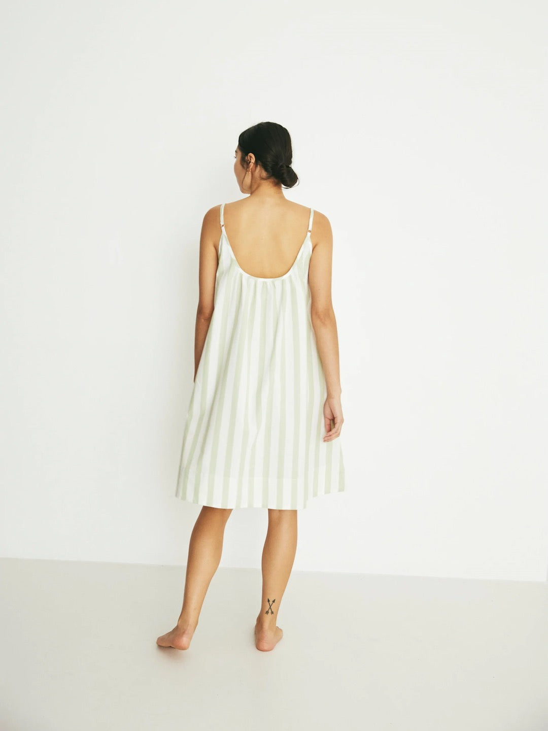 The back view of a woman wearing an Evie Slip - Pear Stripe dress by general sleep.