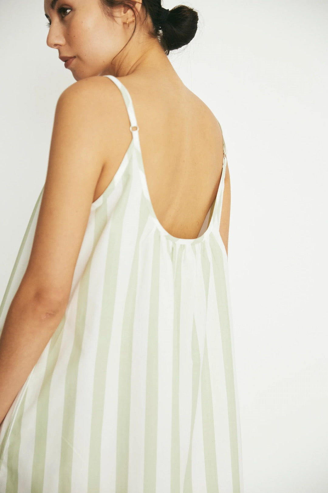 The back view of a woman wearing an Evie Slip - Pear Stripe dress by general sleep.