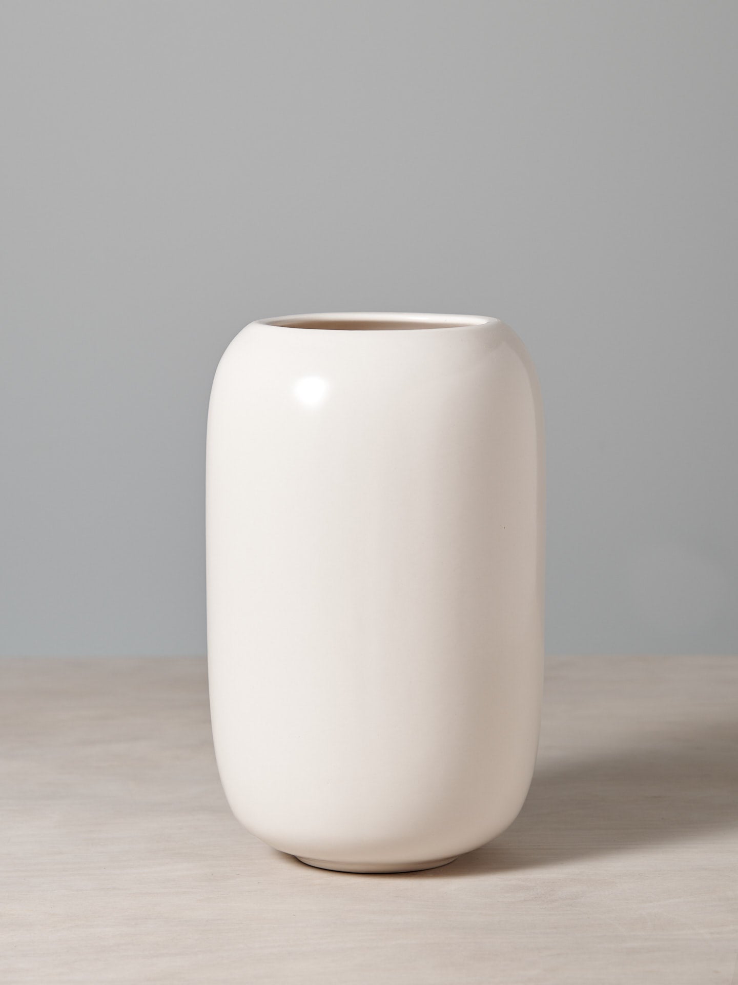 An Ovum Vase - Satin White by Gidon Bing sitting on top of a table.