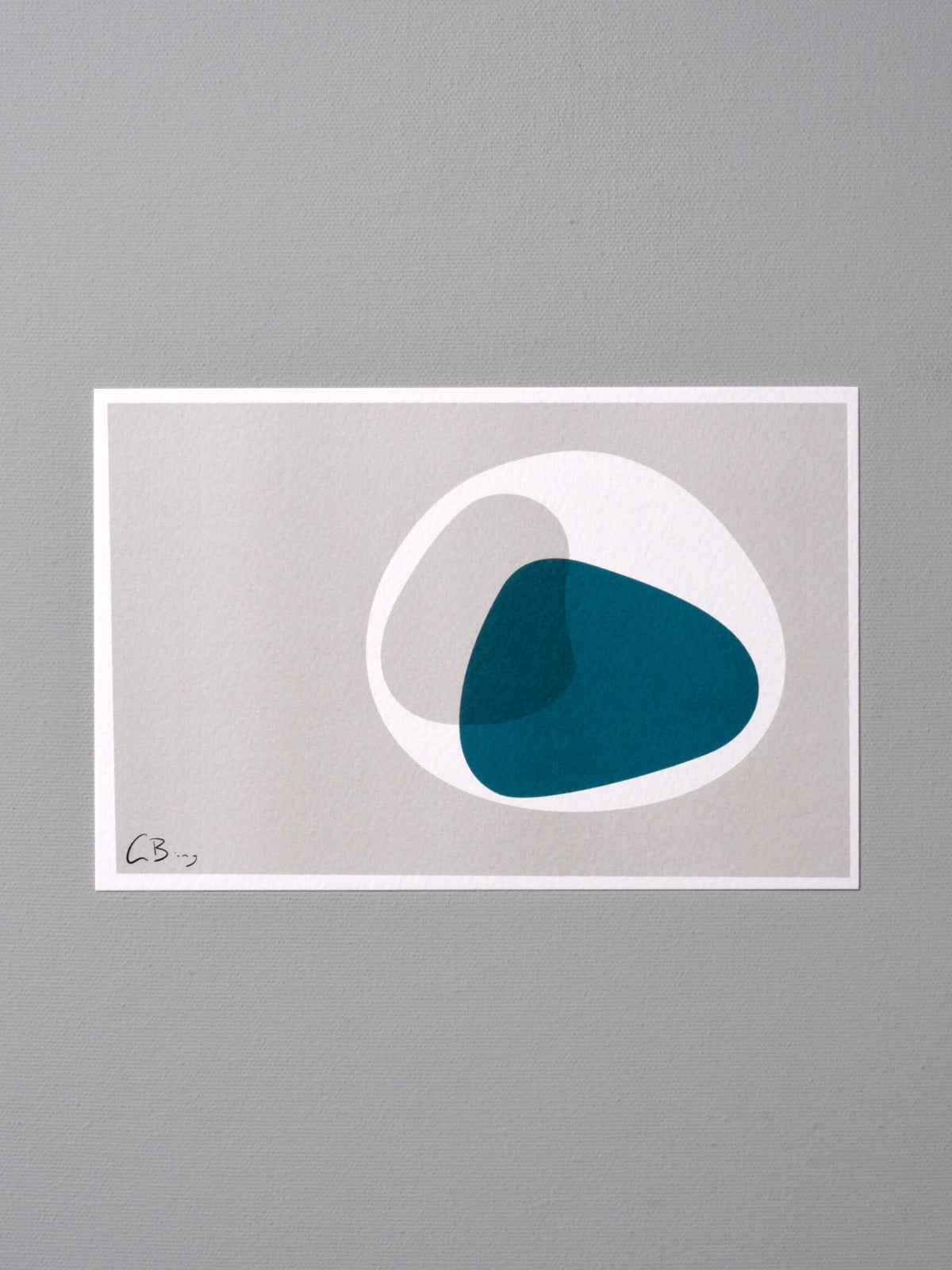A blue and white Postcard Print - Metaphase by Gidon Bing on a gray wall.