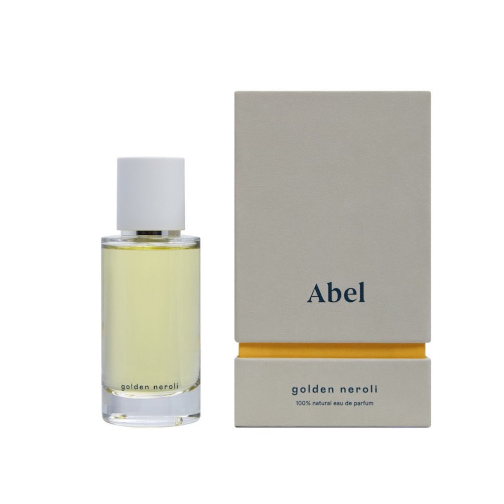 Bottle of &quot;Golden Neroli&quot; natural eau de parfum by Abel next to its packaging.