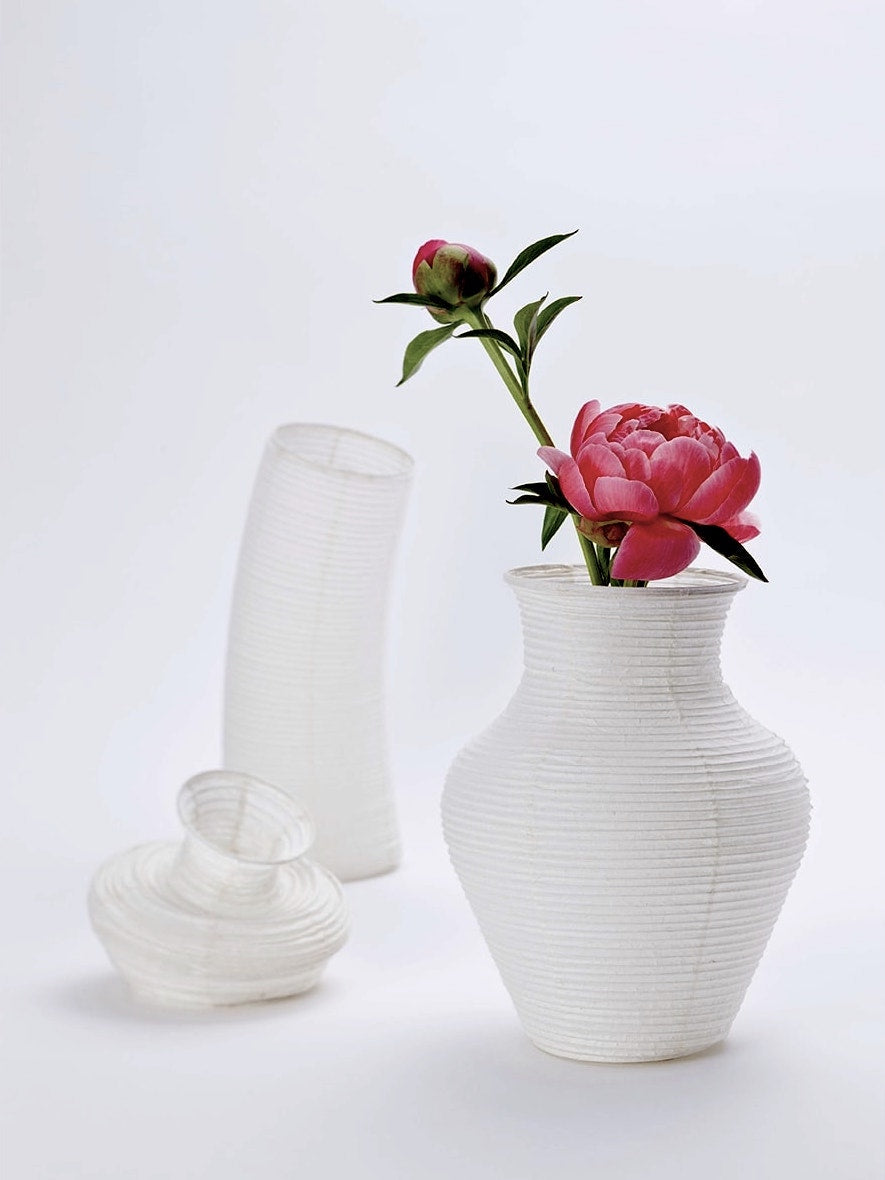 A Nobi-tsutsu Paper Vase - №3 by Hayashi Kougei with a pink flower in it.