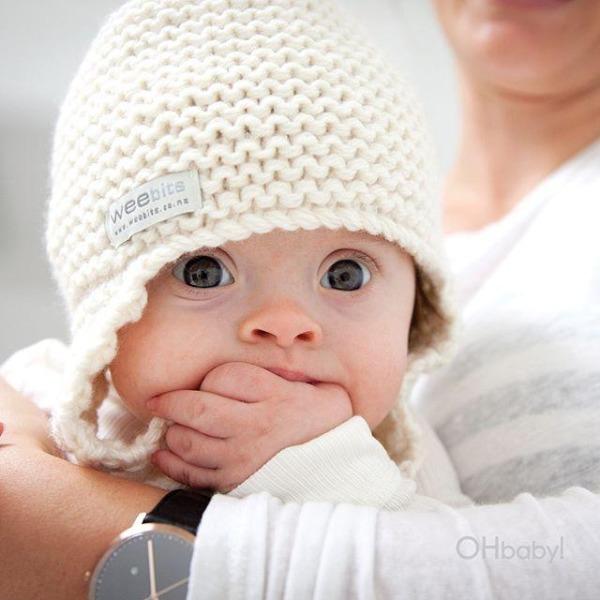 A woman holding a baby in a Weebits Hand Knitted Chunky Knit Hat - Natural.