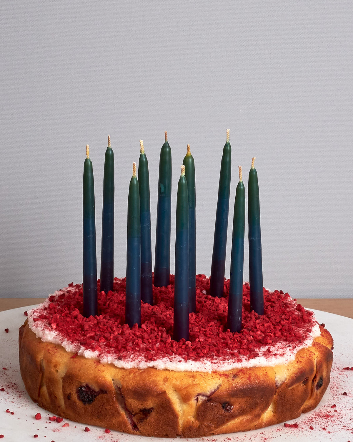 A cake with Hohepa Birthday Candles Set – Green, Blue & Purple on top of it.