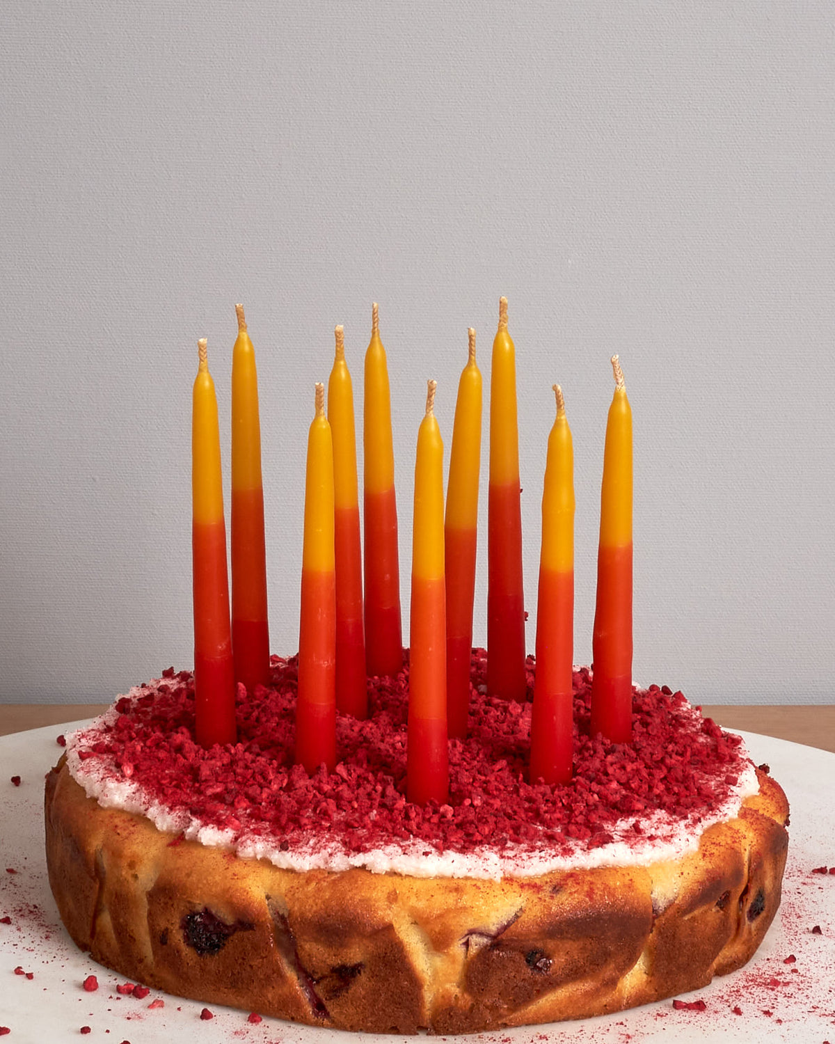 A cake with Hohepa Candles' Birthday Candles Set - Red, Orange & Yellow on top.