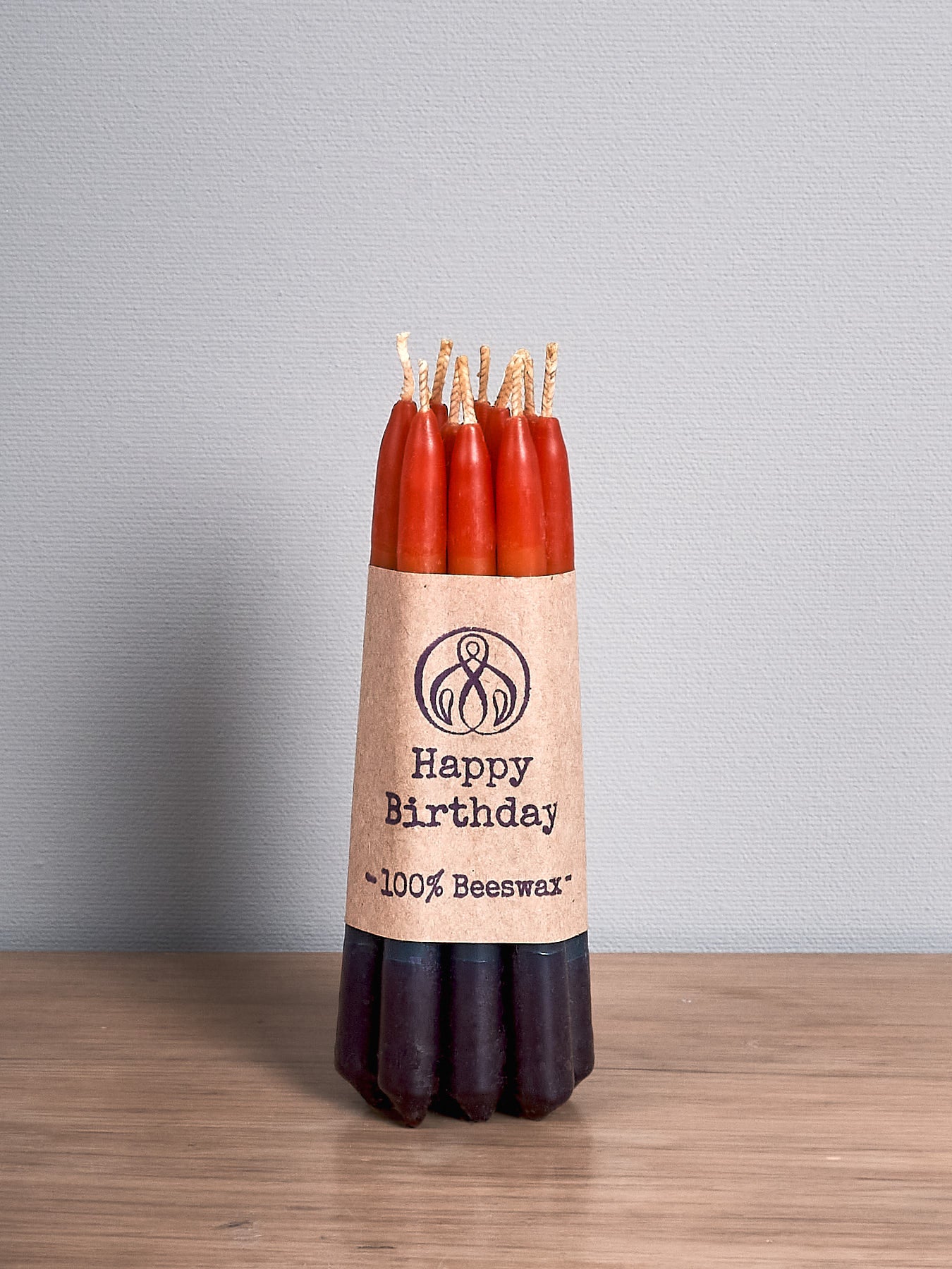 A pack of Hohepa Candles Birthday Candles Set - Rainbow on a wooden table.