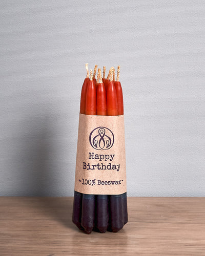 A pack of Hohepa Candles Birthday Candles Set - Rainbow on a wooden table.