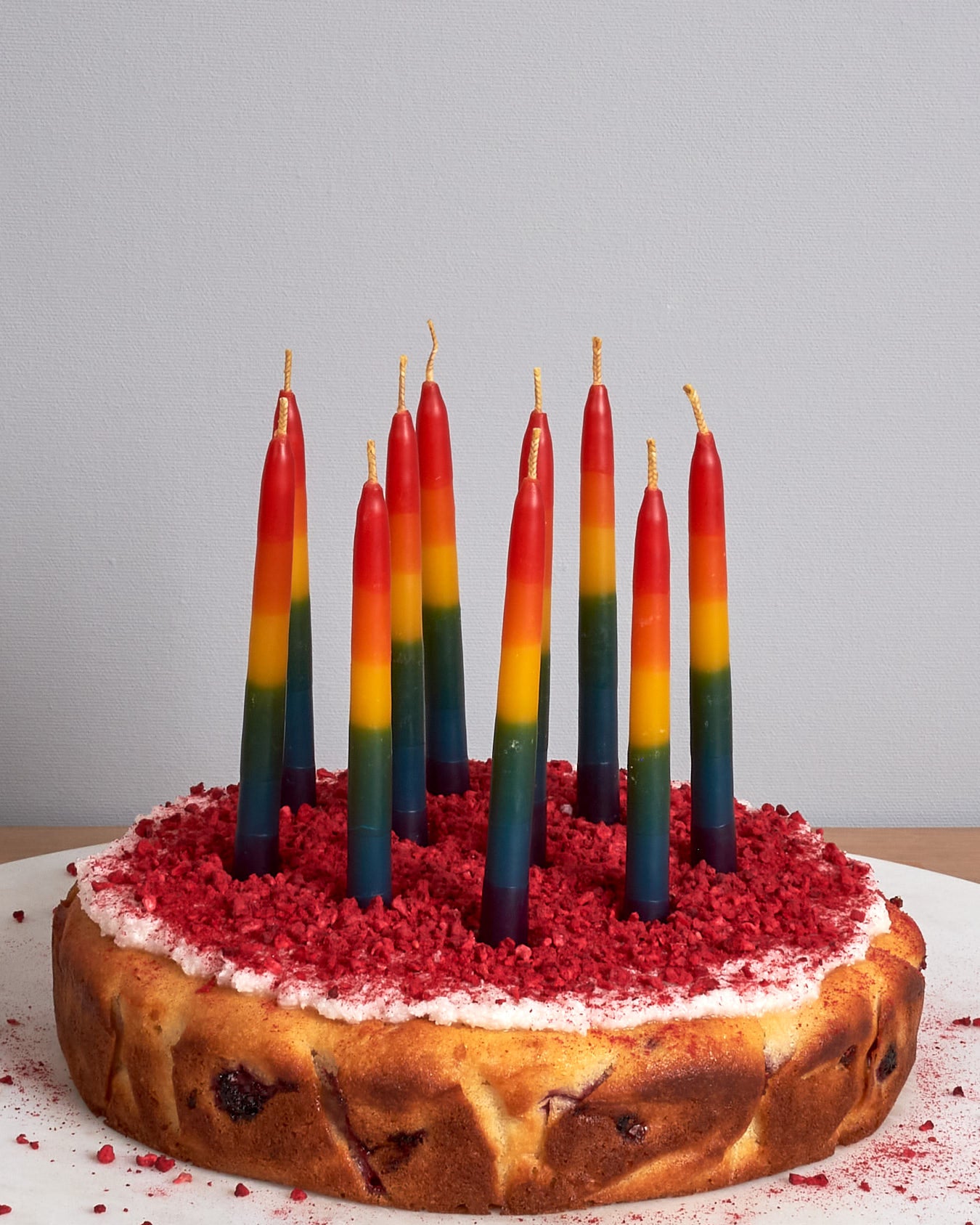 A pack of Hohepa Candles Birthday Candles Set - Rainbow on a wooden table.