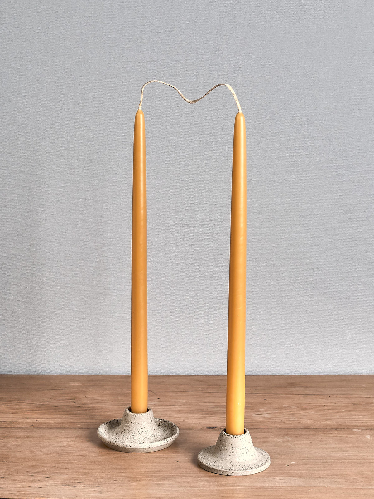Two Hohepa Candles Dinner Candle Set – Natural candle holders on a wooden table.