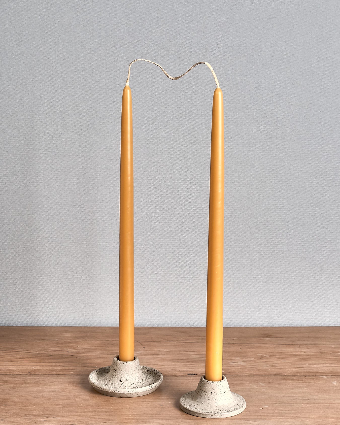 Two Hohepa Candles Dinner Candle Set – Natural candle holders on a wooden table.