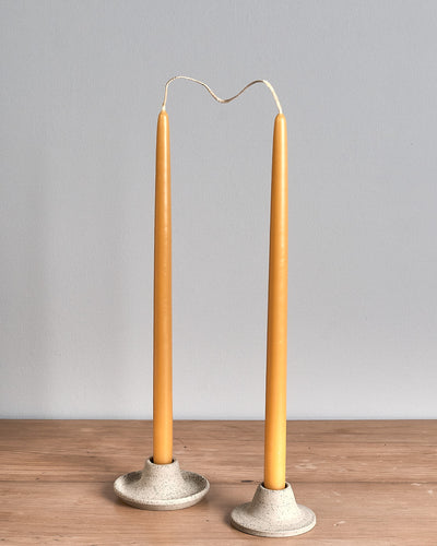 Two Hohepa Candles Dinner Candle Set – Natural candle holders on a wooden table.