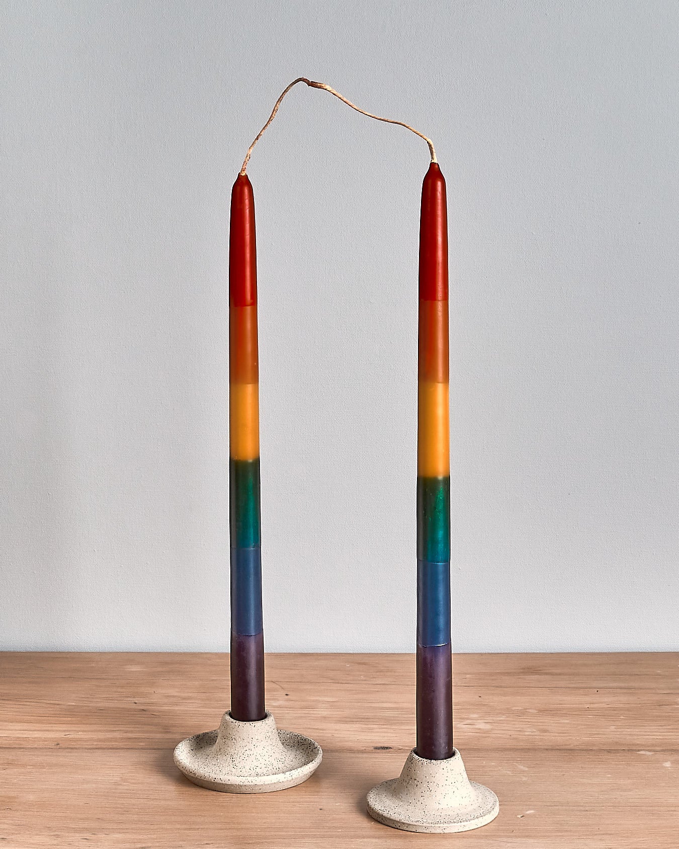 Two Dinner Candle Sets - Rainbow by Hohepa Candles on a wooden table.