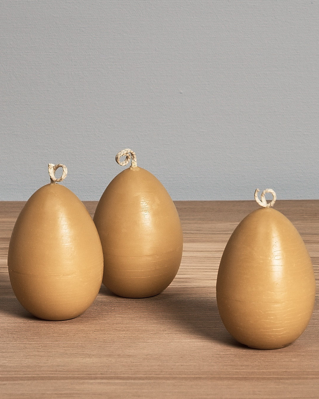 A yellow Hohepa Candles egg sitting on a wooden table.