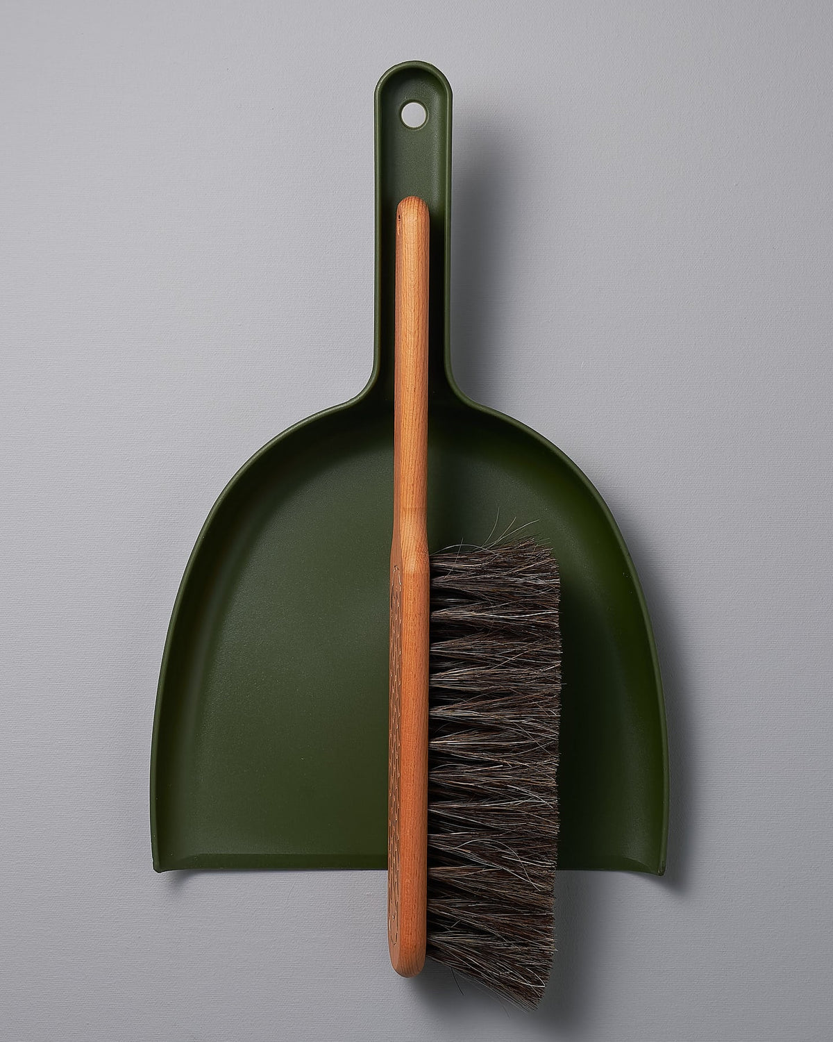 An Iris Hantverk Dustpan & Brush Set – Moss Green with a brush attached to it.