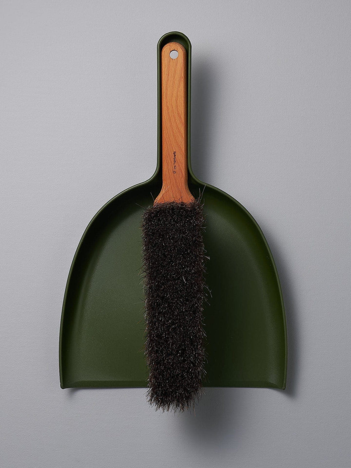 A Dustpan &amp; Brush Set - Moss Green with a brush attached to it. (Brand: Iris Hantverk)