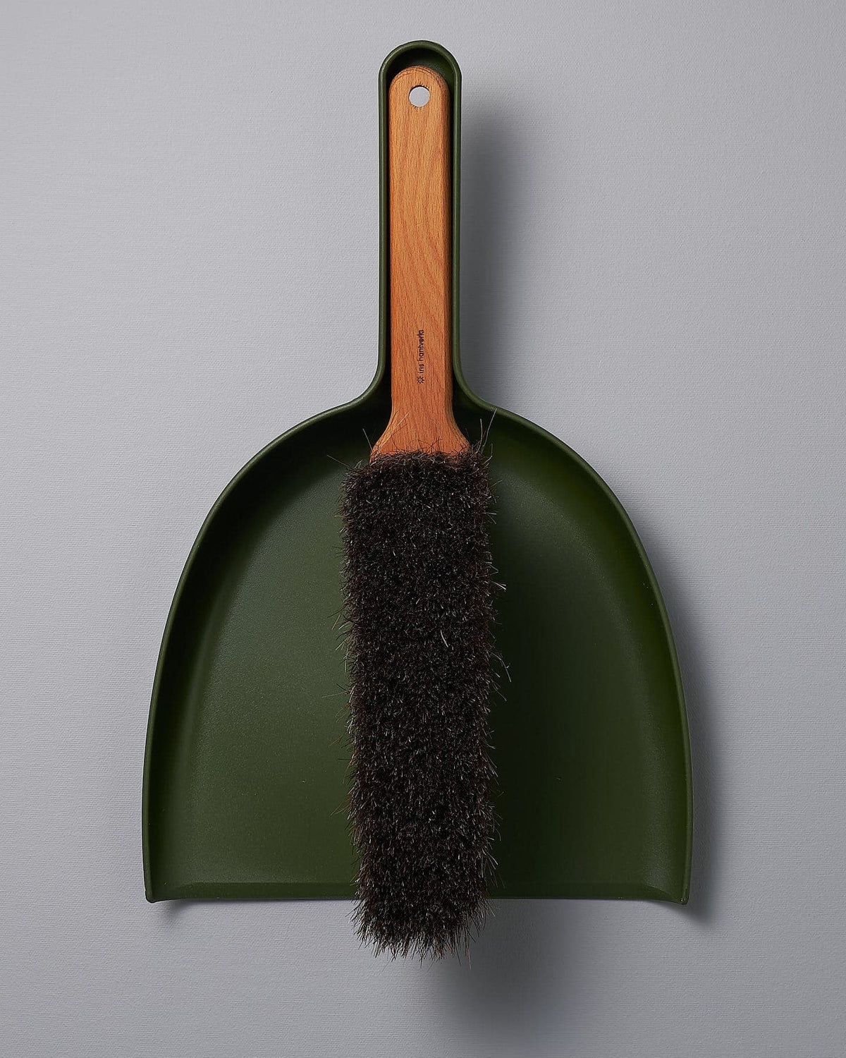 A Dustpan & Brush Set - Moss Green with a brush attached to it. (Brand: Iris Hantverk)