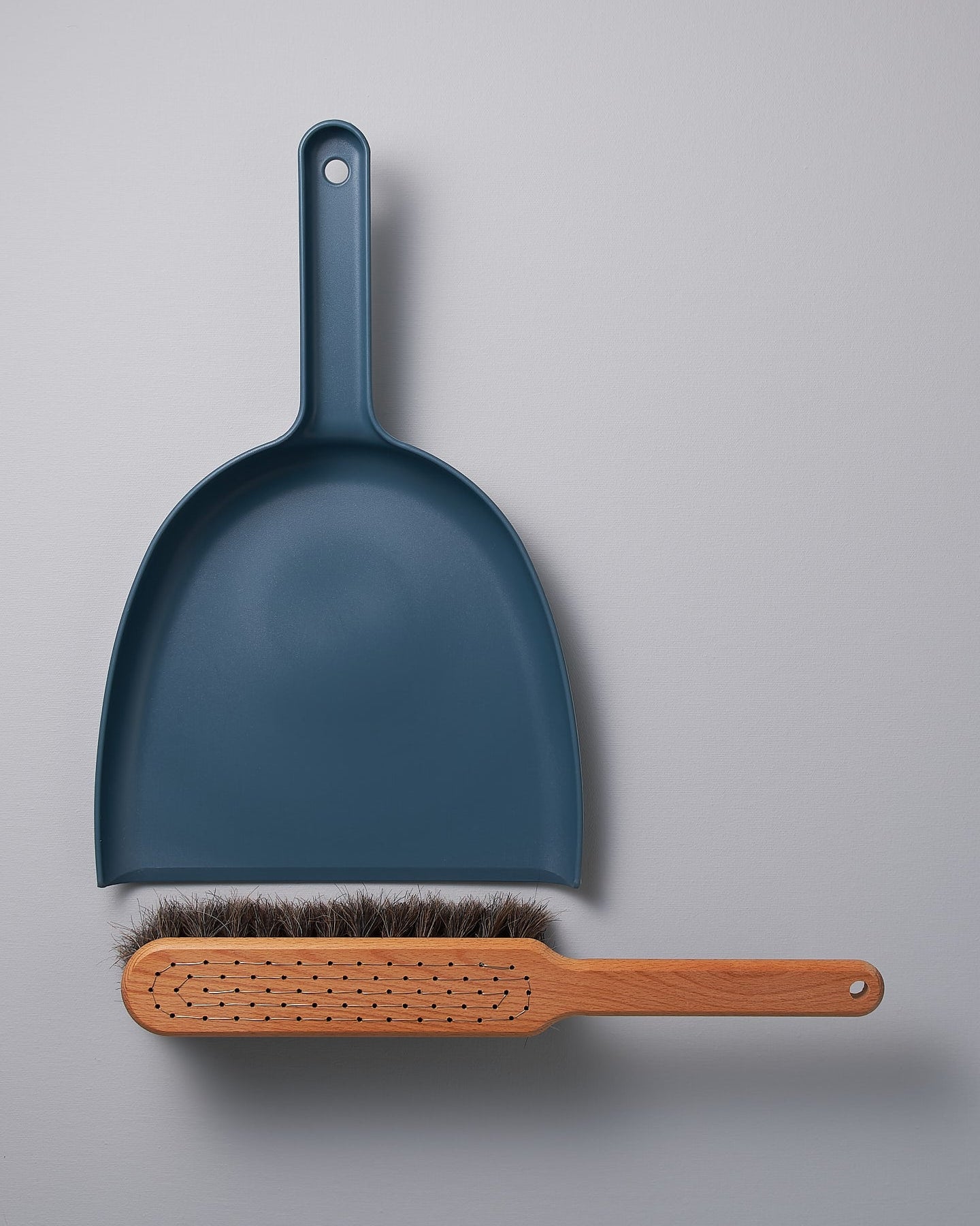 A Dustpan & Brush Set – Petrol Blue by Iris Hantverk on a grey surface.