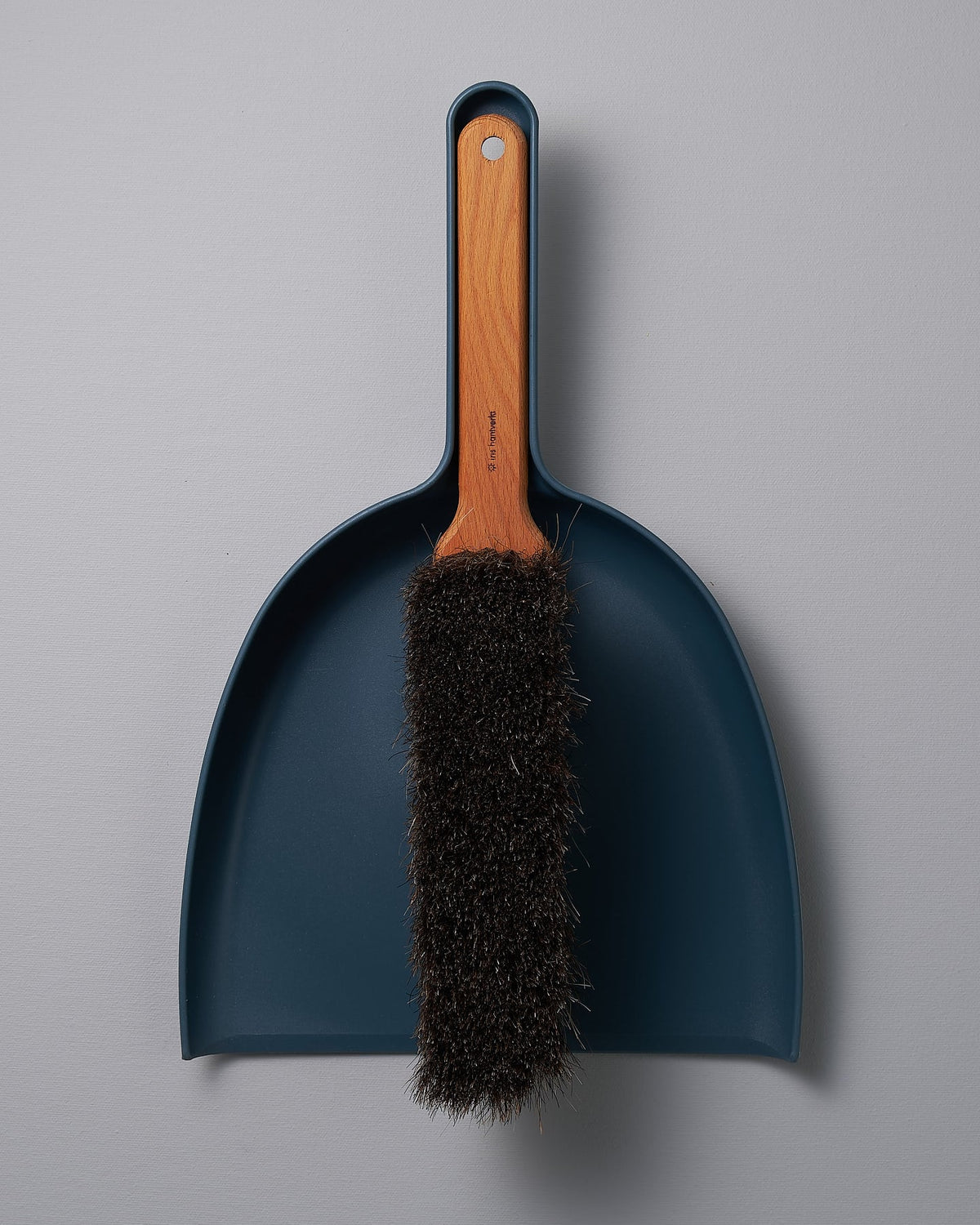 An Iris Hantverk Dustpan & Brush Set – Petrol Blue with a brush attached to it.