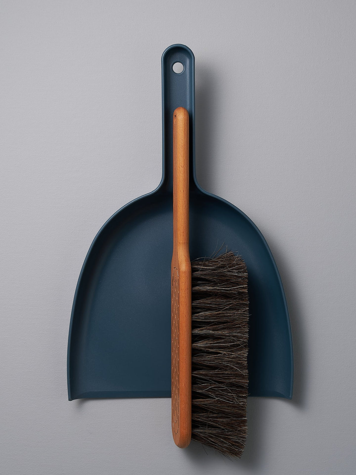 An Iris Hantverk Dustpan &amp; Brush Set – Petrol Blue with a brush attached to it.