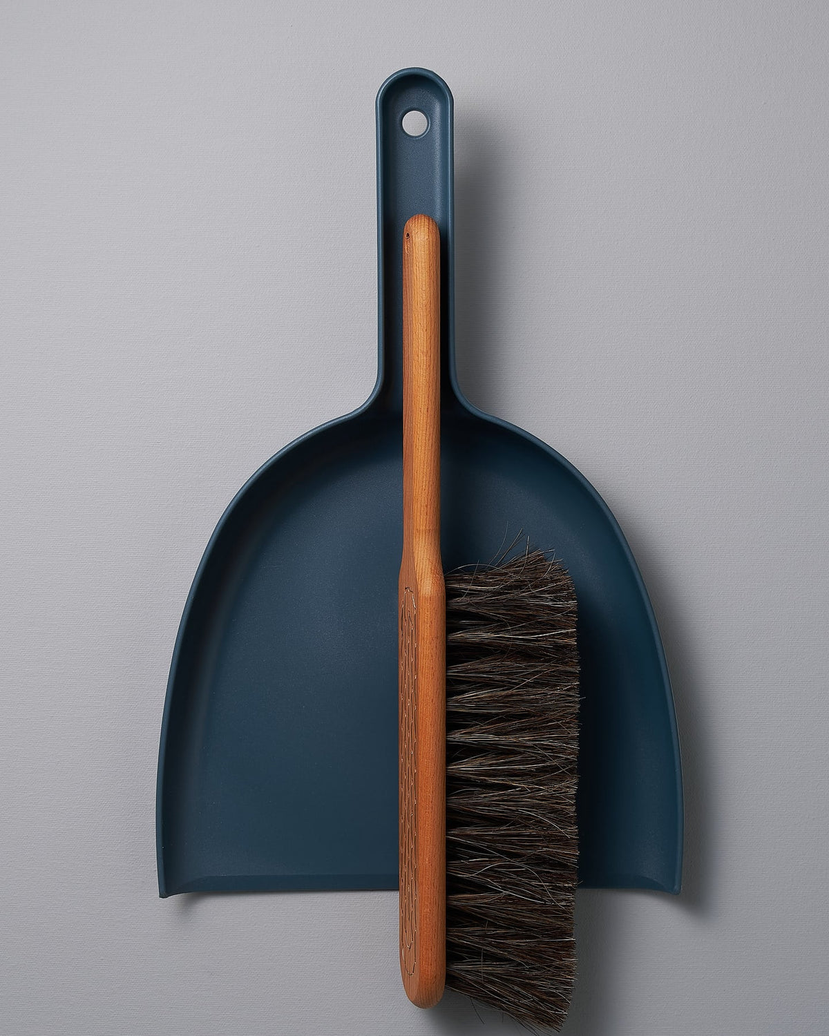 An Iris Hantverk Dustpan & Brush Set – Petrol Blue with a brush attached to it.