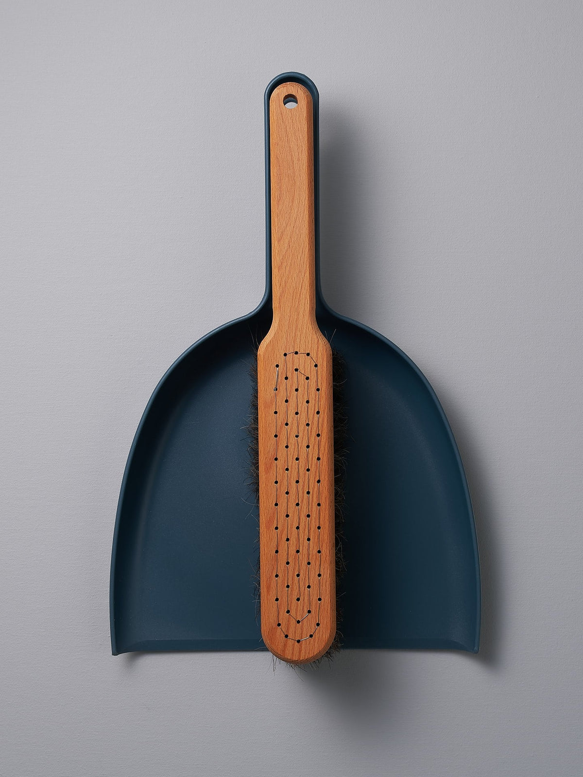 An Iris Hantverk Petrol Blue Dustpan &amp; Brush Set with a wooden handle.
