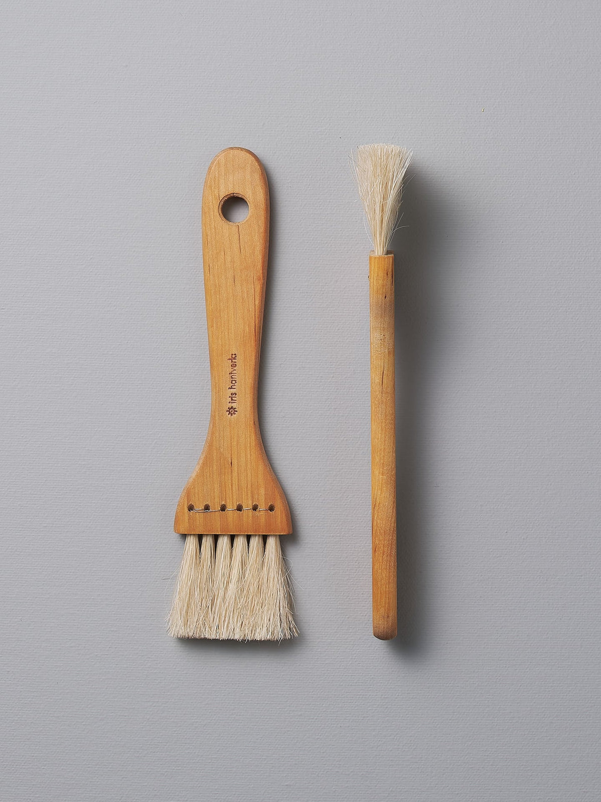 A Pastry Brush – Waxed Birch &amp; Horsehair and a Pastry Brush – Waxed Birch &amp; Horsehair next to each other (brand: Iris Hantverk).