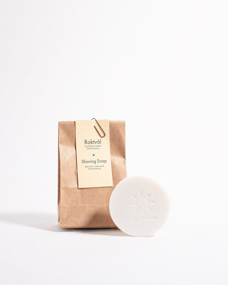 A bar of Iris Hantverk Shaving Soap – Cedarwood next to a brown paper bag.