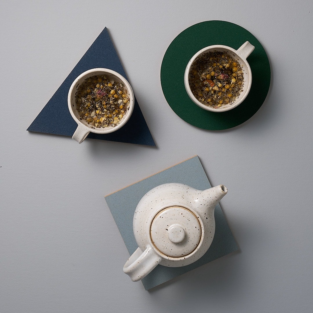 Three Trivet – Orion Blue tea pots and cups by Iris Hantverk on a table.