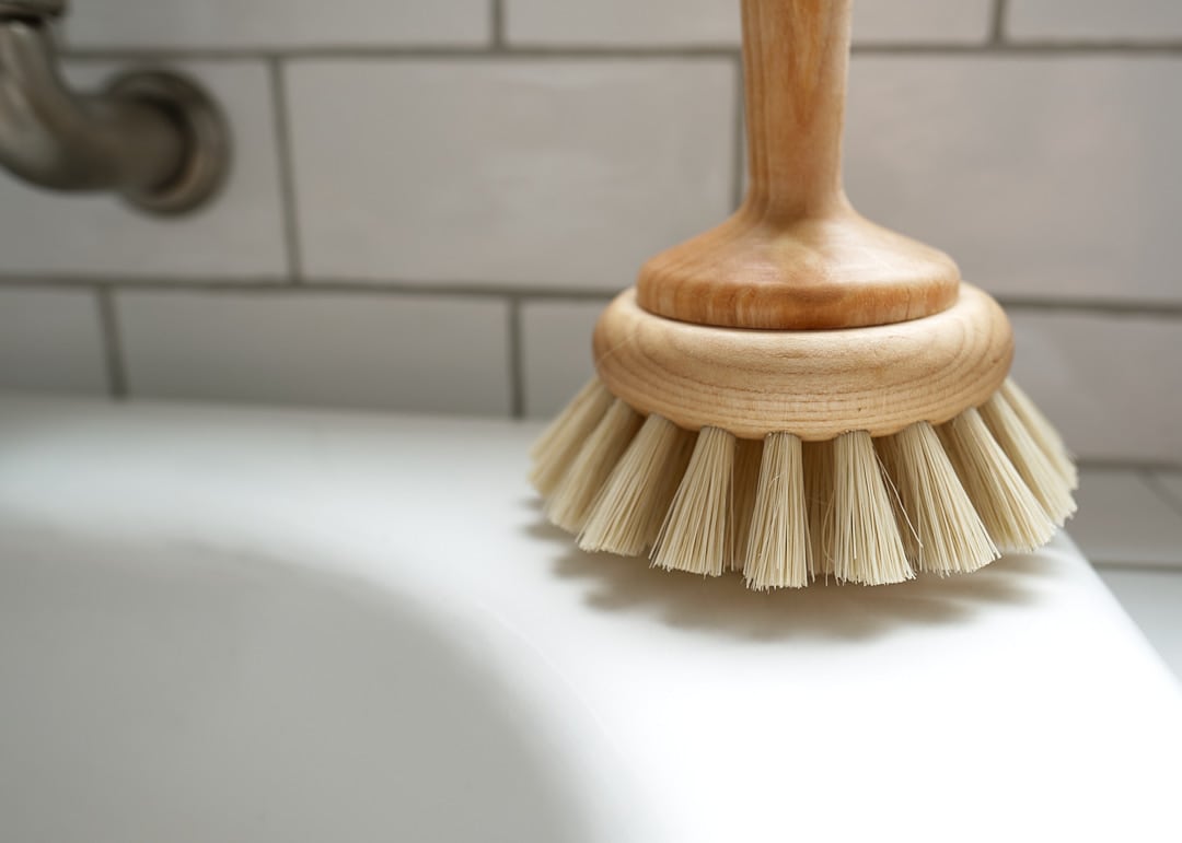 An Iris Hantverk bathroom cleaning brush sits on top of a sink.